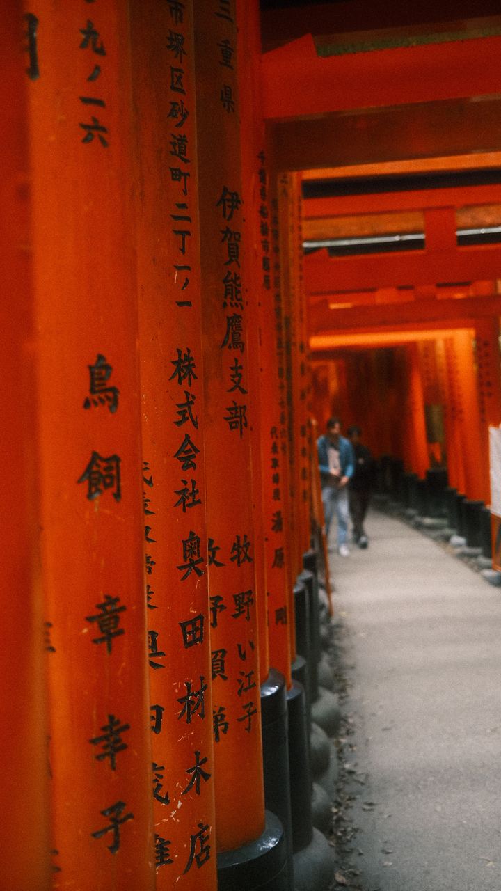 Rows of vermilion torii gates inscribed with black calligraphy, Fushimi Inari, Kyoto